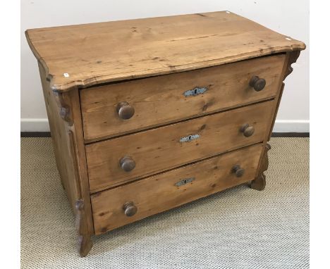A 19th Century French pine commode, the top with serpentine moulded edges over three long drawers with turned knob handles, r