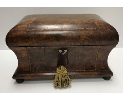 An early 19th Century walnut and parquetry inlaid tea caddy, the domed top opening to reveal two lidded compartments of cante