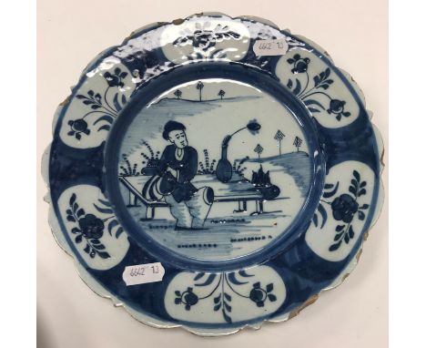 An 18th Century Dutch Delft chinoiserie decorated plate with figure seated upon a table, with flask, 23 cm diameter, together