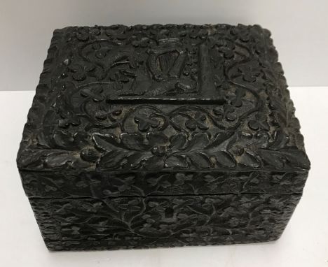 A circa 1900 Irish carved bog oak box, the lid decorated with crown, harp and seated hound motif amongst scrolling shamrock, 
