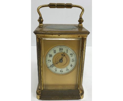 A circa 1900 French lacquered brass cased carriage clock 12.5 cm excluding handle, the white enamel circular dial set with Ar