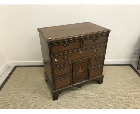 An 18th Century North Country oak and cross-banded chest, the plain top with applied moulded edge over two short and one long