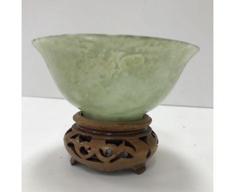 A mutton fat jade bowl of simple flared form, raised on a circular foot, 10 cm diameter x 4.5 cm high, together with associat