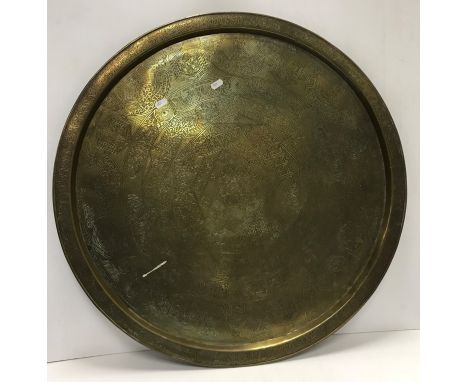 An engraved brass circular Benares type table top, 69.5 cm diameter, an 18th Century Dutch pewter charger, 32 cm diameter, a 