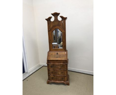 A modern walnut bureau bookcase in the 18th Century Continental manner, the broken arch pediment over a mirrored door enclosi