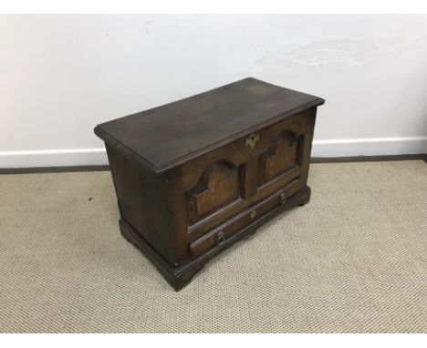 An 18th Century oak coffer bach, the plain top with moulded edge above two domed fielded panels and single slim drawer on bra