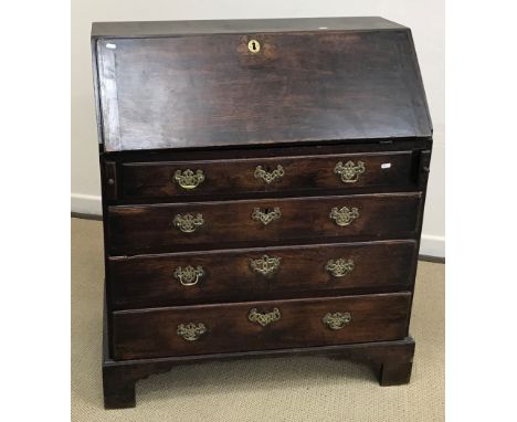 An early 19th Century oak bureau, the plain top above a sloping fall front enclosing a basic fitted interior over four gradua