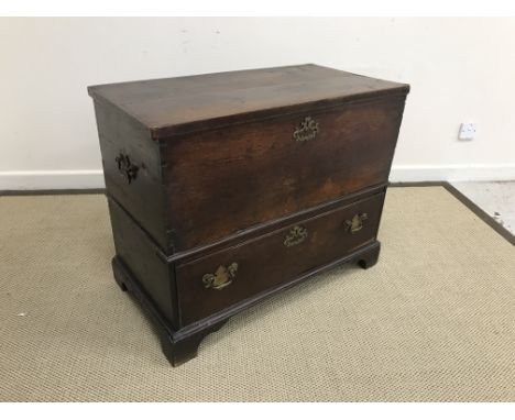 An 18th Century oak mule chest, the plain top opening to reveal a candle box with two drawers, over a single drawer, raised o
