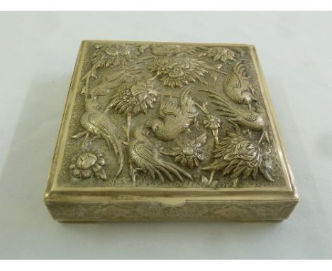 A Persian white metal square box, the hinged cover embossed with birds and flowers on four bracket feet