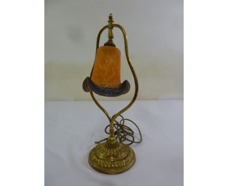 An Art Nouveau style table lamp with glass shade on raised circular brass base