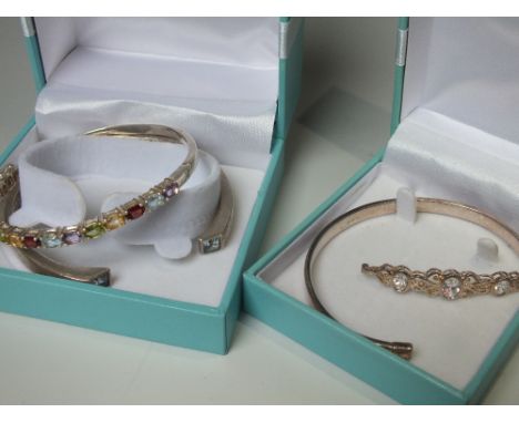 A HALLMARKED SILVER MULTICOLOURED GEMSET SILVER BANGLE, together with two further gemset silver bangles (3)