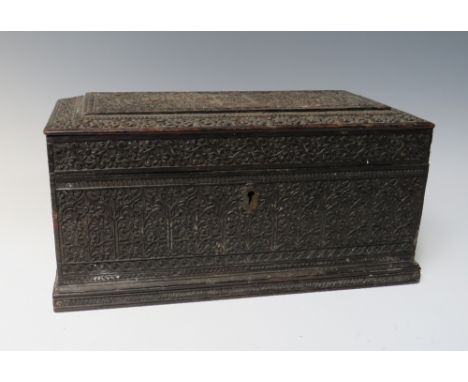 AN ANTIQUE INDIAN CARVED EBONISED HARDWOOD TEA CADDY, with profuse engraved decoration throughout, the hinged lid opening to 