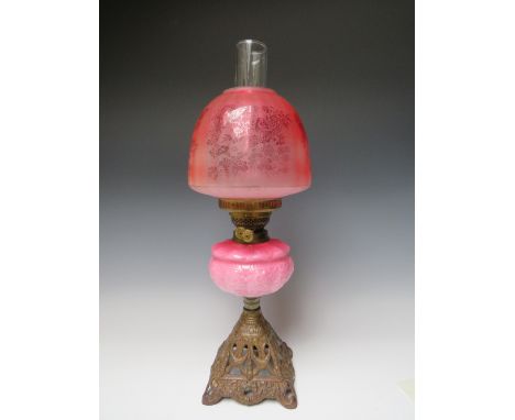 A LATE 19TH / EARLY 20TH CENTURY OIL LAMP, having graduated pink opaque pressed glass reservoir, twin burner, ruby glass shad