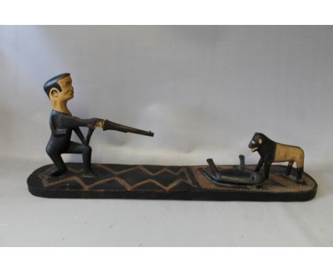 A LARGE EAST AFRICAN MAKONDE TANZANIA TRIBAL ART CARVED SCENE OF A HUNTER, with rifle and dog, Colonial period, circa 1950