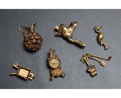 A COLLECTION OF NOVELTY CHARMS,  consisting of hallmarked gold and unmarked yellow metal examples, marked examples are a pier