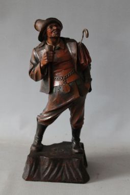 A 20TH CENTURY BLACK FOREST FIGURE WITH DRINK AND UMBRELLA, H 32 cm, together with a small Black Forest lidded pot with carve