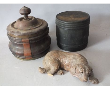 A VINTAGE CARVED  BLACK FOREST RECUMBENT DOG S/D, together with a cylindrical tea caddy having image to screw top etc., (3)