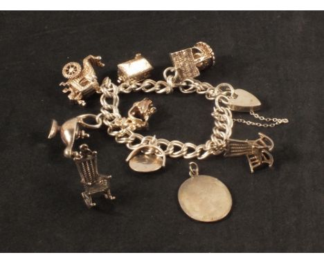 A silver charm bracelet with various charms including wishing well, Aladdins lamp and a St Christopher pendant