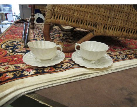 Four Belleek shell form tea cups and saucers and a cream jug, black stamp to base