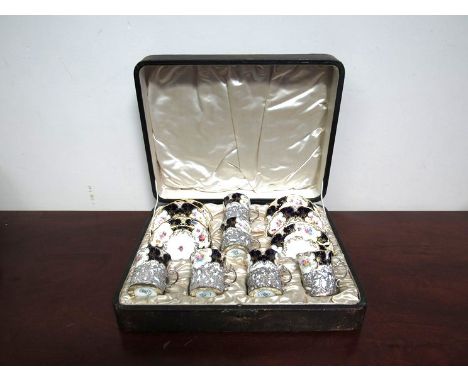 A set of six Coalport coffee cans and saucers with pierced silver holders, cased 