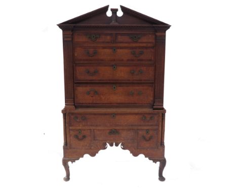 An 18th century oak chest on a stand, fitted with two short over three graduated long cross banded drawers to the upper secti