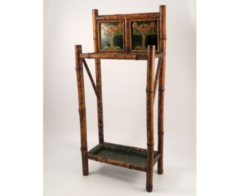 A bamboo two division stick stand, the back set with two Art Nouveau style tiles, with tray below, width 15ins