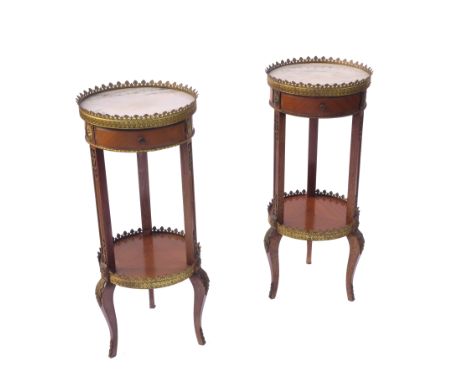 A pair of circular pot stands, with marble top surrounded by castellated gilt gallery with drawer below, raised on three legs