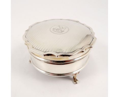 A circular silver dressing table box, the engine turned cover engraved with an armorial, Sheffield 1926, maker Walker and Hal