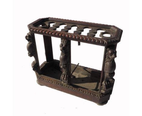 A twelve division oak stick stand, with three bold carved lion masks to the front, width 33ins