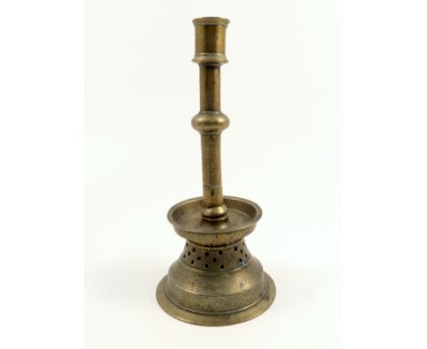A Mamluk style brass candlestick, with knopped stem to a circular tray raised on a base with pierced band and engraving, heig