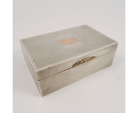 A silver cigarette box, with engine turned decoration, gilt initialled panel and clasp, London 1949