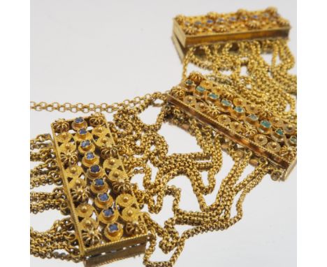 A Victorian gold and gem set bracelet, composed of three cannetille rectangular panels, one set with a line of emeralds and t