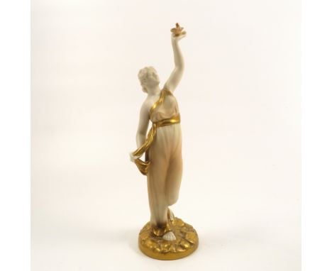 A Royal Worcester blush ivory and gilt Classical figure, modelled as a woman with her hand in the air holding a bird, shape n