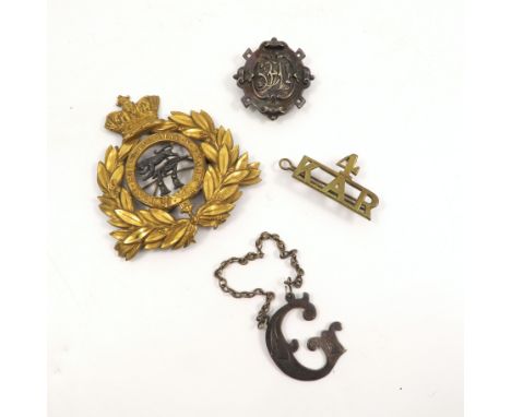 A gilt metal military cap badge, with crown, laurel wreath surrounding a lion over 17 and Honi Soi Qui Mal Y Pense, together 