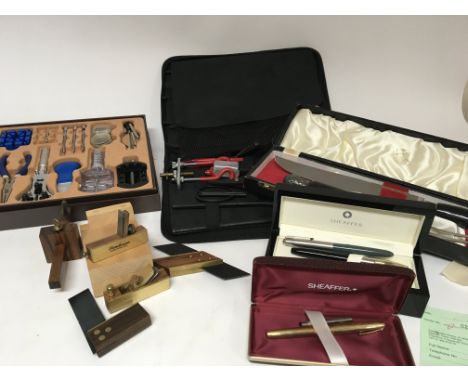A collection of items comprising a watch repair tool kit one other specialist tool kit miniature brass and wood Sanderson woo