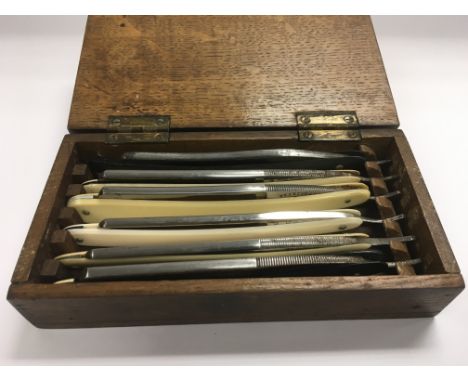 Six vintage straight razors in a fitted wooden case.