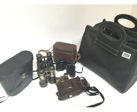 A collection of binoculars and cameras and a camera bag (a lot)