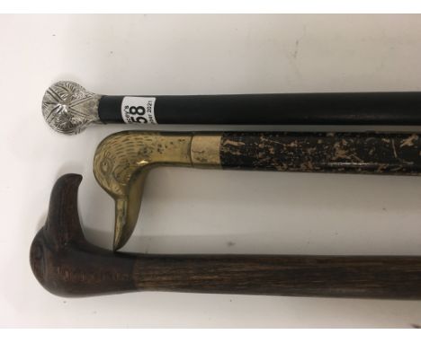 A silver top walking cane one other walking cane with carved birds head and part stick .