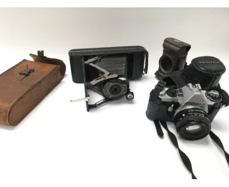 A vintage Lucas bike lamp and two cameras with cases.