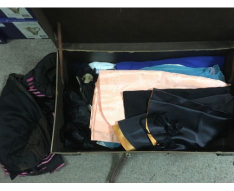 A vintage suitcase containing various embroidered linen, dresses, bags etc.