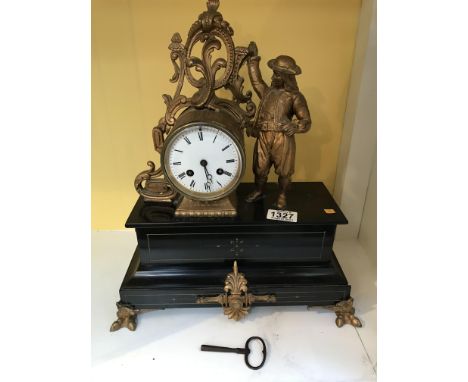 A Victorian slate mantel clock with a gilt case and gilt claw feet, flanked by a sailor.