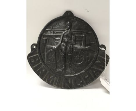 A lead Birmingham fire insurance plaque, depicting a fireman with helmet, uniform and boots, in front of a manual fire engine