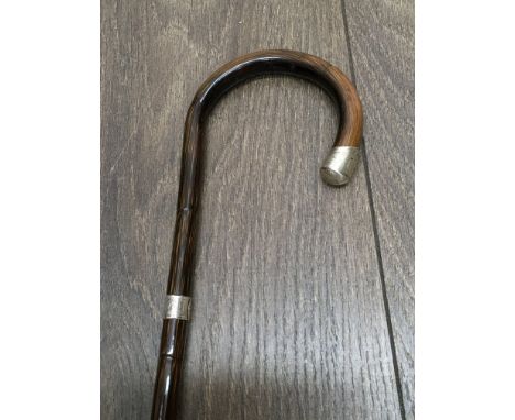 A walking stick with two silver bands.