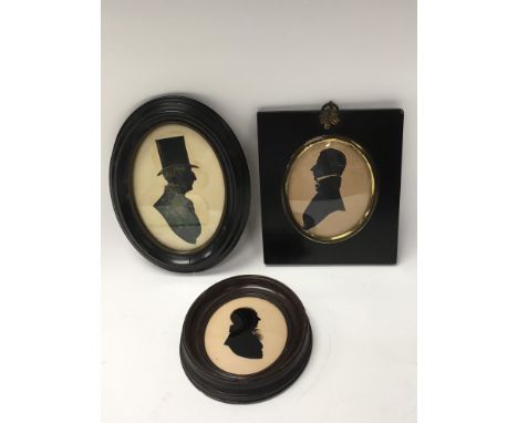 Three framed silhouette portrait miniatures.