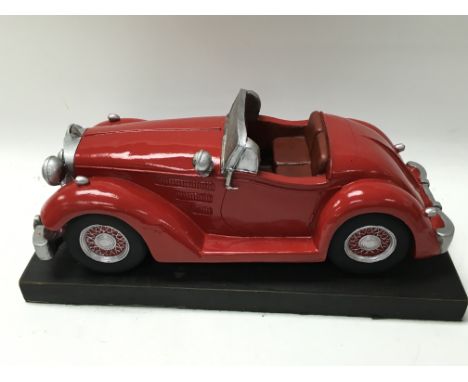 A model for a red Mercedes vintage car on a wooden base.