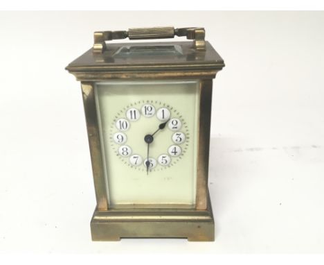 A brass cased carriage clock with a coloured dial and raised white numerals not seen working.