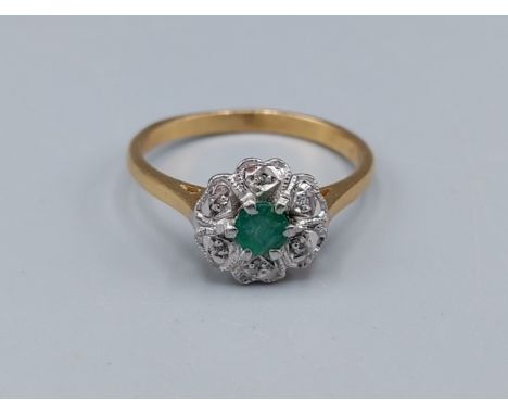 An 18ct gold ring set with a central Emerald surrounded by Diamonds, 2.8gms, ring size M