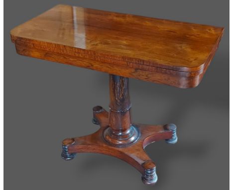 A William IV Rosewood card table, the hinged top enclosing a beize lined interior above a tulip carved column and platform ba
