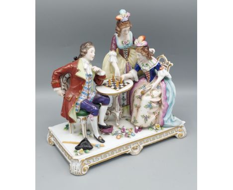 A Sitzendorf porcelain group 'The Chess Players' decorated in polychrome enamels and highlighted with gilt, 22cms tall