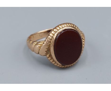 A 15ct gold Signet ring set with an oval red stone, 7.1gms, ring size Q